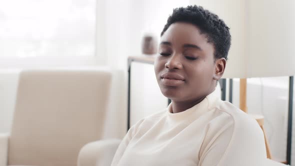 Portrait Afro American Girl Ethnic Model with Short Hair Looking to Side Sitting in Profile at Home