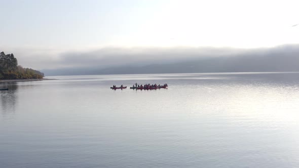 A Team of Canoeists on a Lake in the Early Morning