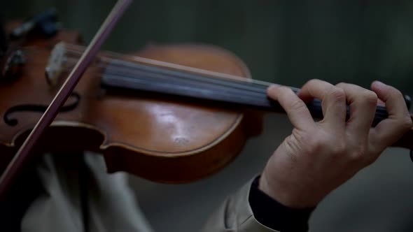 Violin and Bow in Hands of Talented Musician Closeup View Fiddler is Rehearsing