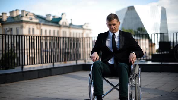 Disabled Businessman Trying to Get Up From Wheelchair Outdoor