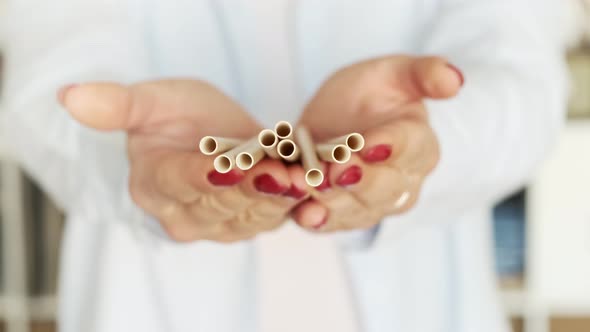 Zero Waste. Woman holding a decaying material paper bamboo eco-friendly drinking straw.