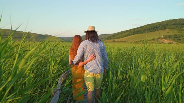 Couple walking in a reed field in the afternoon
