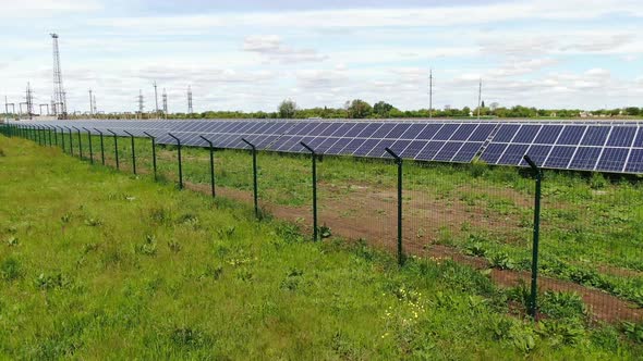 Aerial View Over the Fence of the Solar Power Station in the Field, 