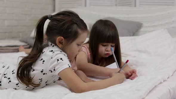 Kids Drawing Pictures While Lying on Bed