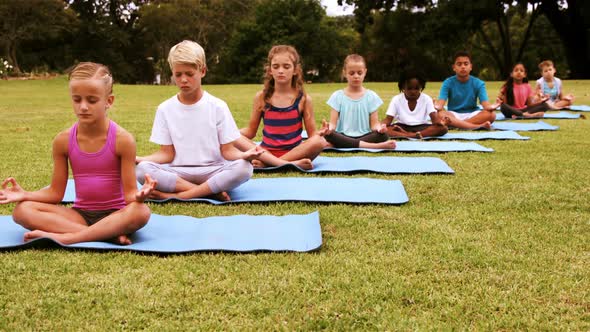 Group of kids performing yoga in park