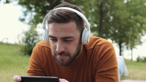 Man Playing Mobile Game in Park