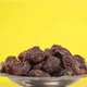 dried large dates on a metal plate that rotates, yellow background - VideoHive Item for Sale