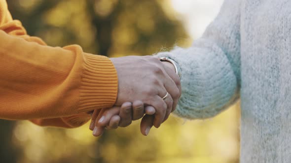 Close Up of Hands of an Elderly Couple in the Park on Autumn Day