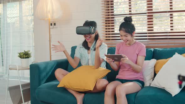 Female feeling happy fun and virtual reality, VR playing games together while lying sofa.