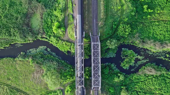 Metal Structure Railway Bridge Over a Small River and the Trees of a Forest