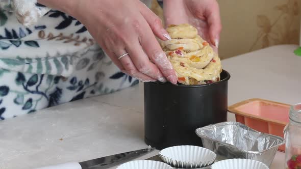 The Woman Puts The Cruffin In A Baking Dish. Prepares Cruffin With Raisins And Candied Fruit