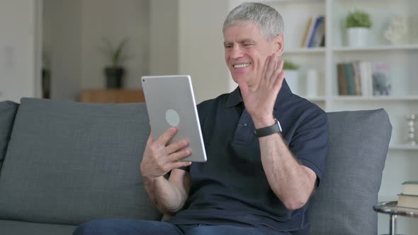 Middle Aged Businessman Doing Video Chat on Tablet at Home