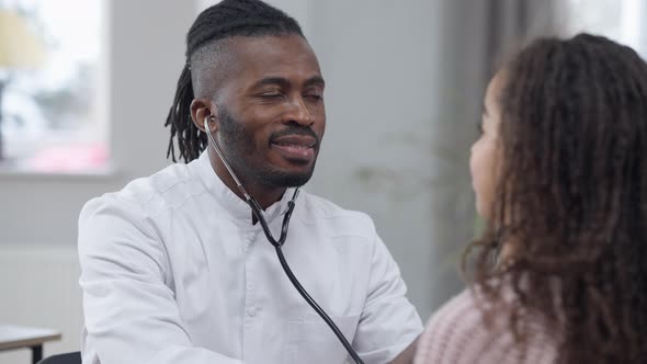 Portrait of African American Male Doctor Listening to the Internal Sounds Using Stethoscope