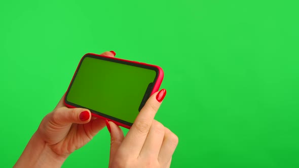 Female Hand Holds Mobile Phone with Workspace Mock Up Screen on Green Background in Horizontal