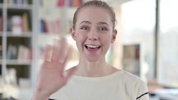 Portrait of Cheerful Young Woman Waving at the Camera