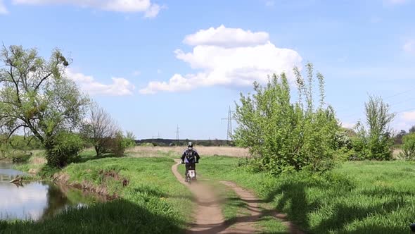 Male motocross driver riding his FMX motorcycle on the extreme off-road track