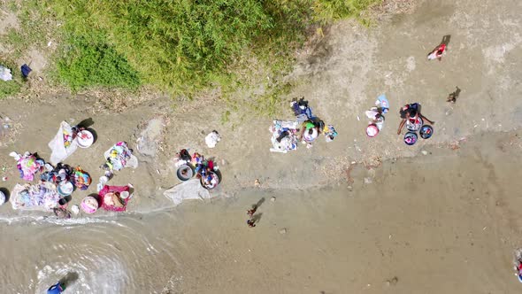 Haitian women washes clothing in Dajabón river on international border; aerial