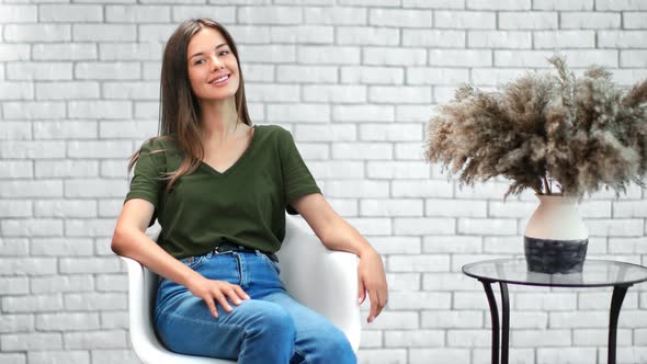 Happy Casual Woman Sitting on Armchair Smiling Having Positive Emotion