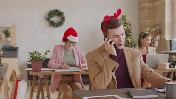 Businessman in Festive Headband Posing in Office on Christmas