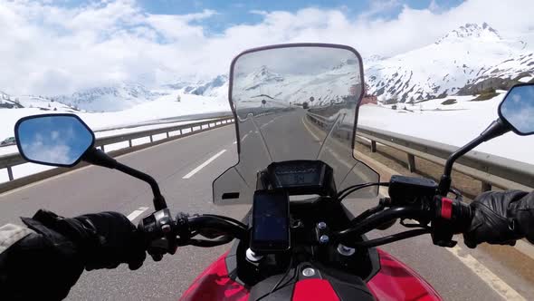 Motorcyclist Rides on Beautiful Landscape Snowy Mountain Road Near Switzerland Alps