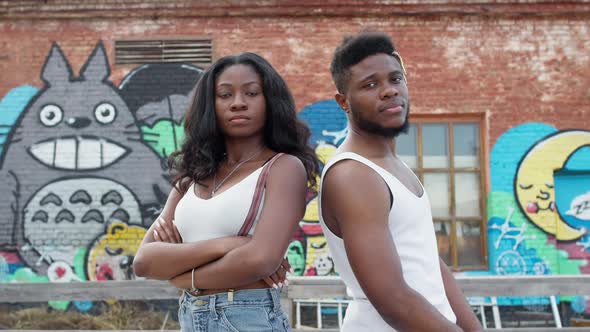 Young Couple On Graffiti Wall Background. Black Guy And Girl.