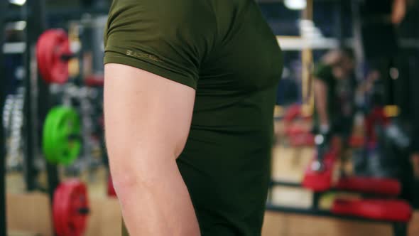 Closeup View of a Sporty Man's Strong Hand Doing Dumbell Curl Exercises in Gym