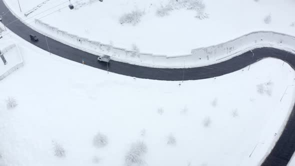 Aerial Fpv View Asphalt Serpentine Road with Movement Vehicle at Blizzard Winter Landscape