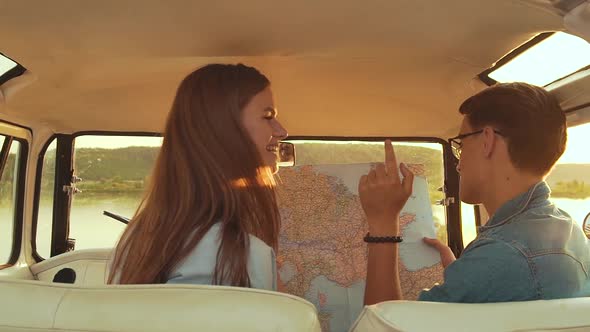 Friends Using Map Traveling In Car In Summer. Handsome Man And Beautiful Woman