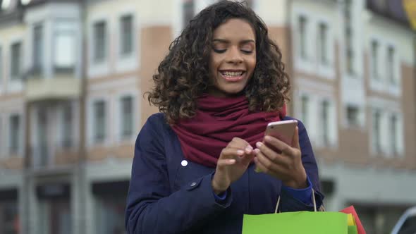 Mixed Race Woman Checking Online Store Apps on Modern Smartphone, Shopping
