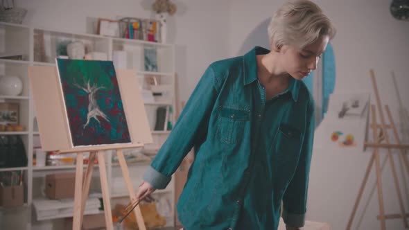 A Young Woman Artist Sits on the Chair on the Art Studio