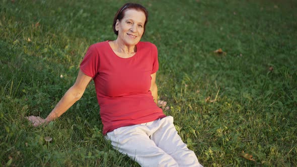 Elderly Woman Sitting on the Grass