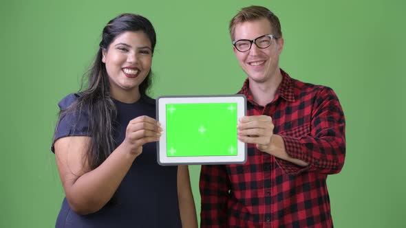 Young Multi-ethnic Business Couple Together Against Green Background