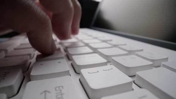 Close-up typing on keyboard with man fingers. Macro soft focus dolly shot.