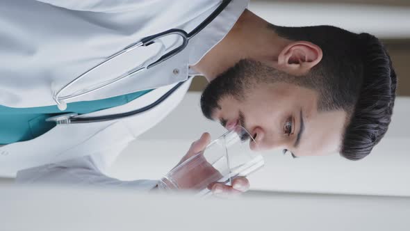 Vertical View of Young Man Thoughtful Arabian Doctor Wear White Medical Coat Looking Through Window