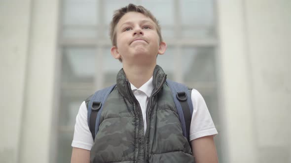 Portrait of Upset Caucasian Schoolboy Raising Head and Sighing. Sad Boy Having To Go To School To