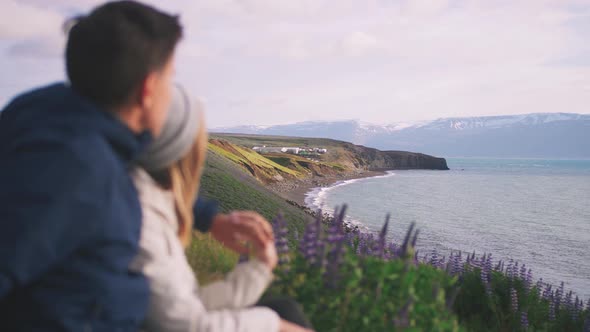 Young Couple Hugging and Enjoying the Spectacular View on Iceland Coastal Mountains
