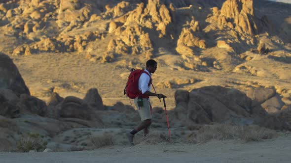 A young man backpacking in a mountainous desert.