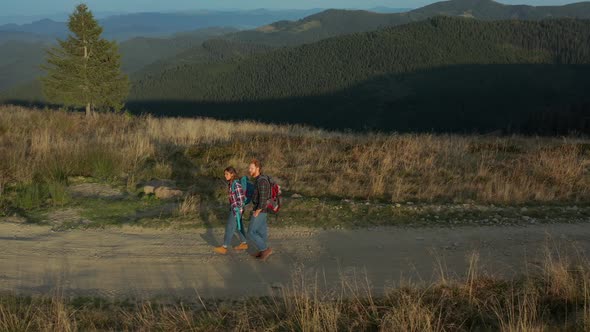 Drone Tourists Backpacks Walking Mountains Path Talking Against Green Hills