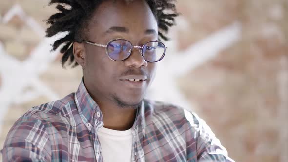 Close-up of Smiling Young African American Man in Eyeglasses Showing Thumb Up and Clapping Hands in