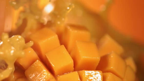 Slow Motion Shot of Mango Juice Splashing Through Mango Cube Slices