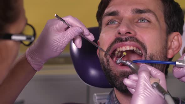 Portrait of Brunette Man During Teeth Polishing