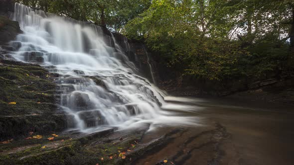 Time lapse of forest waterfall in rural landscape during autumn in Ireland. alt