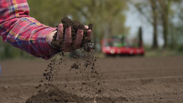 Close-up of Hand, Farmer, Agronomist Checks Quality of Soil on Farm Field. Background of Working