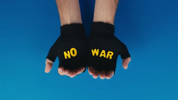 Hands with Black Gloves Reveal No War Text