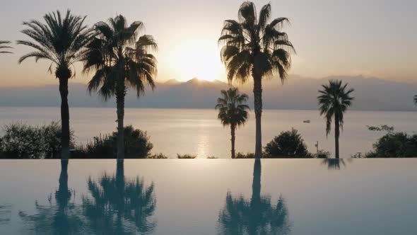 A Steadicam Shot of an Open Pool Boundary and the Sunset By the Sea Behind It