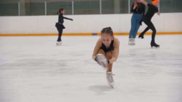 A Little Girl Ice Skating on the Public Rink and Performing a Spinning Trick