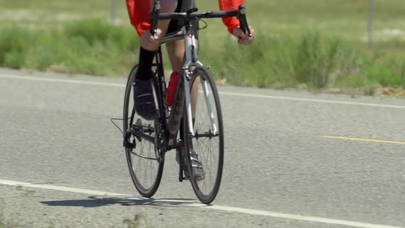 A man road biking on a scenic road.