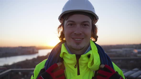 Climber with Skein of Rope on Shoulders Smiles to Camera