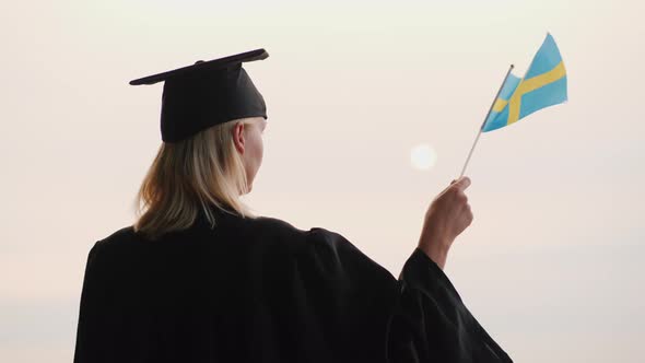 Education in Europe  Graduate in Mantle and Cap with Sweden Flag in Hand