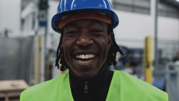 Happy African engineer man working inside robotic factory - Tech industry concept
